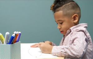 Image of child drawing with markers